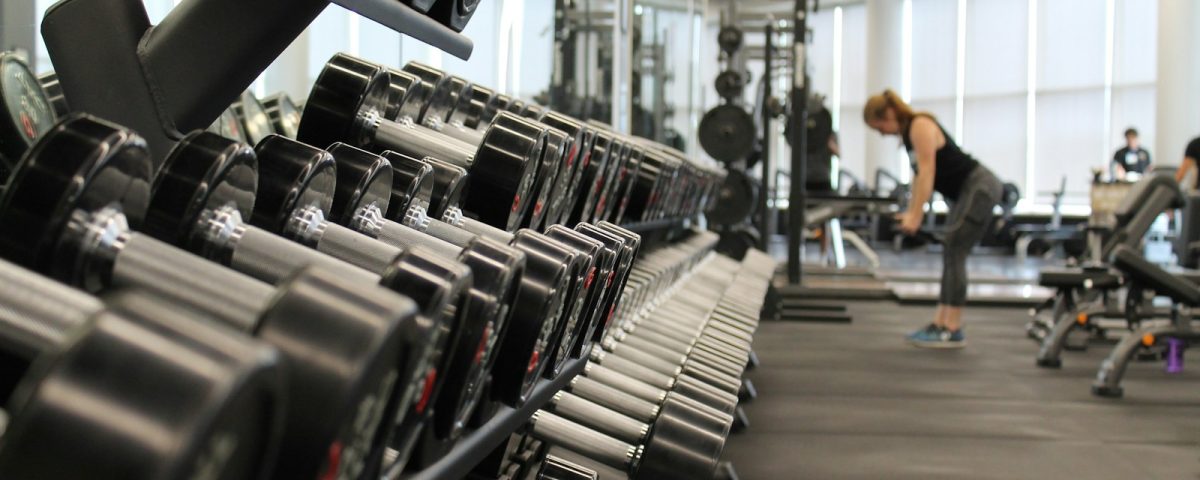 woman standing surrounded by exercise equipment