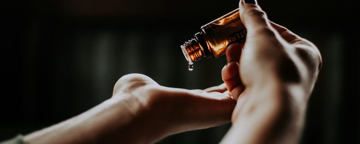 person holding amber glass bottle